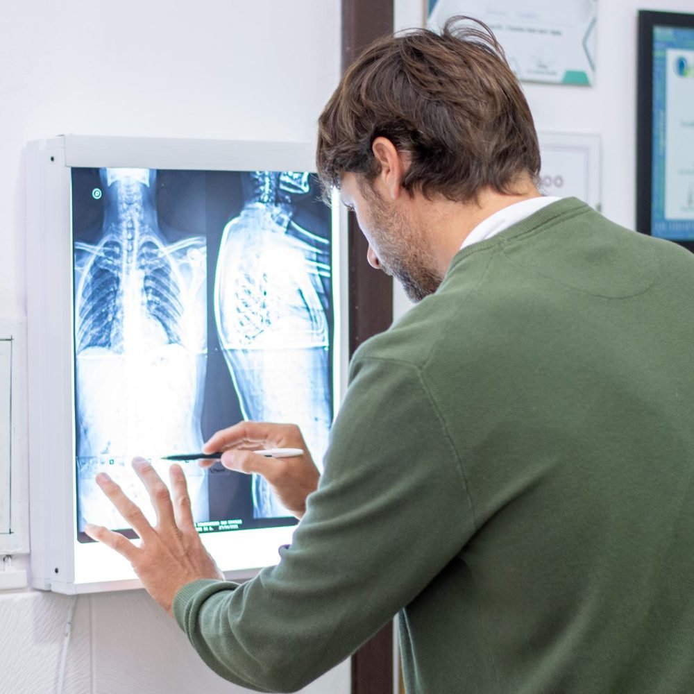 Luciano revisando una radiografía de columna